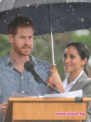 Бременната Меган пази своя принц от дъжда